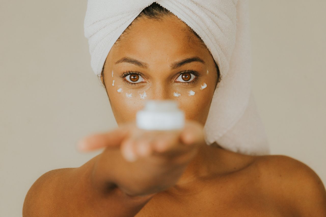 Femme présentant un soin cosmétique